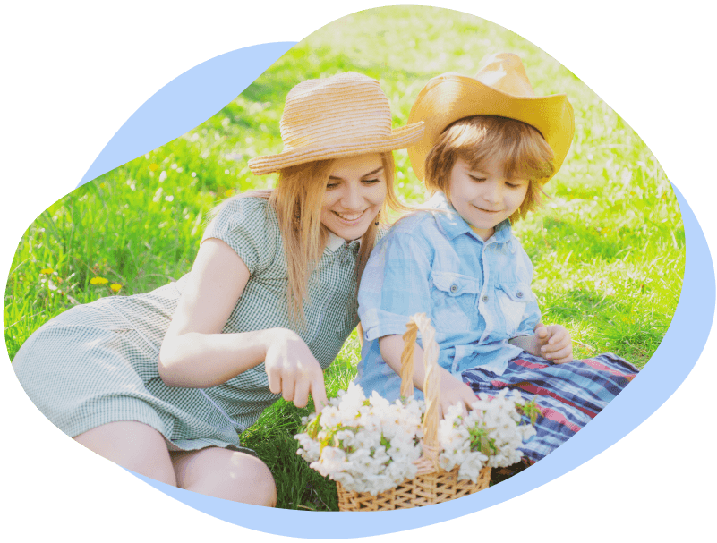 Smiling mother and son collecting flowers in the field